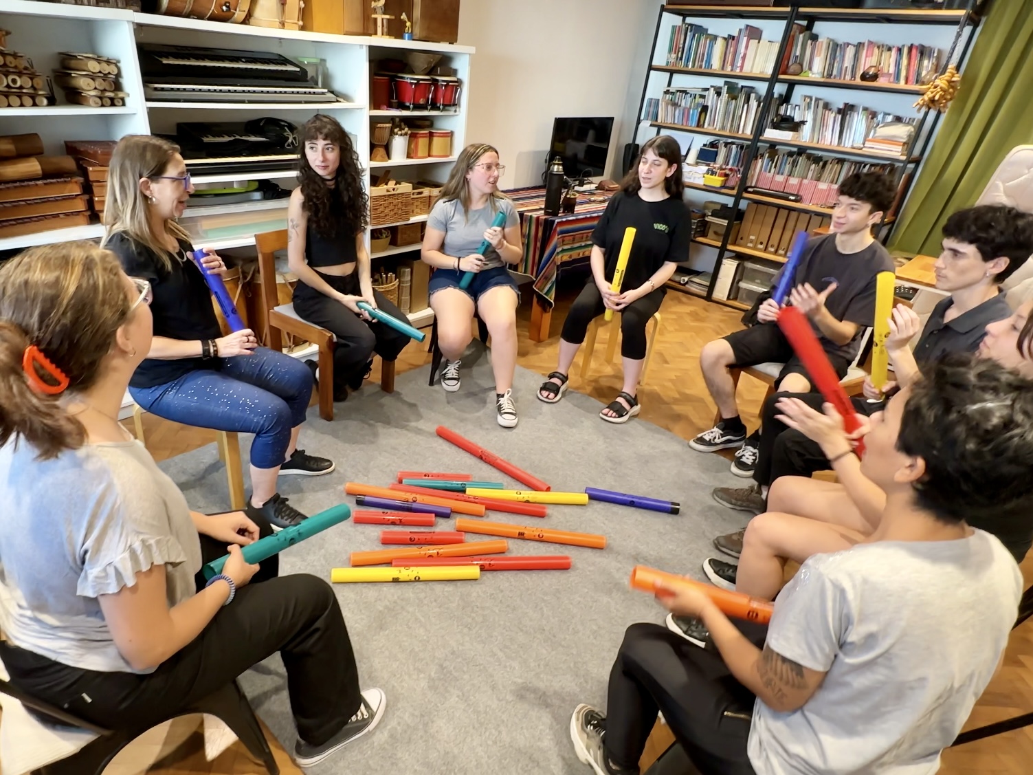 Grupo de estudiantes en ronda usando Boomwhackers en clase de música